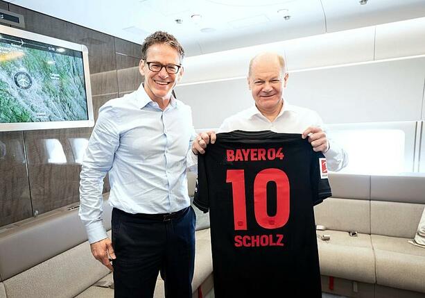 Bild vergrößern: Scholz lässt sich mit Leverkusen-Trikot ablichten