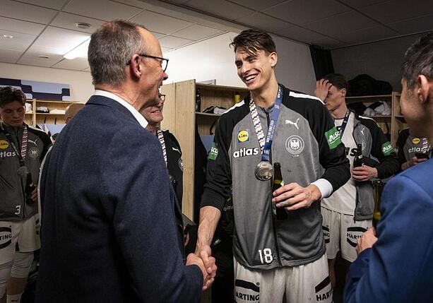 Bild vergr&ouml;&szlig;ern: Merz gratuliert deutschen Handballern in der Kabine